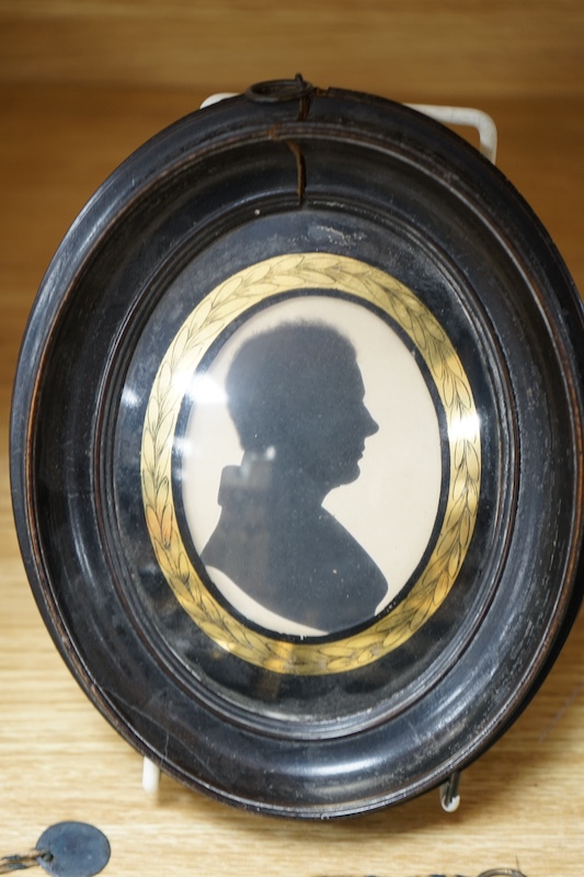 A family group of five 19th century silhouettes in ebony frames, largest 9cm high. Condition - fair